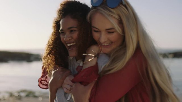 portrait of young woman surprise hug best friend on sunny beach seaside enjoying laughing together