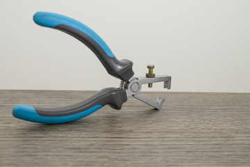 Tools, blue electric wire stripper on a decorated wood table