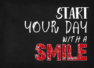 Start your day with a smile, words on blackboard background.