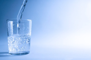 Naklejka na ściany i meble Glass of water in blue light