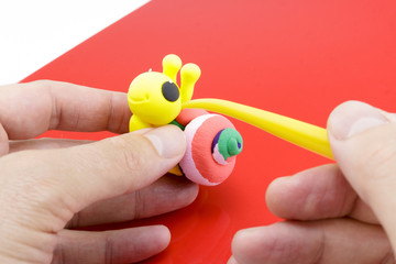 Hands Crafting a Colorful Snail Out of Modeling Clay