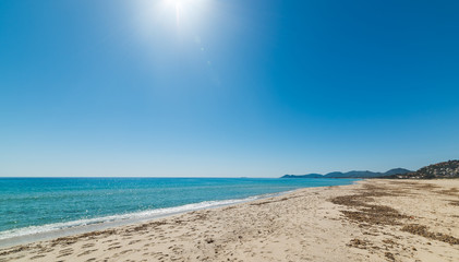 Sun shining over colorful Costa Rei shoreline in Muravera