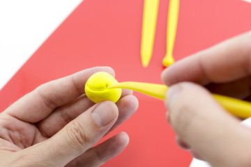Hands Shaping Figure Out of Ball of yellow Modeling Clay