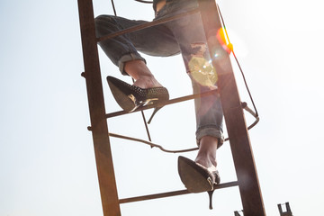 Woman climbing the metal ladder