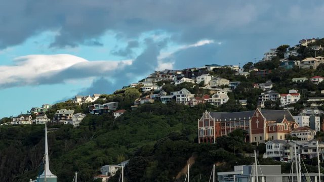 Time lapse of clouds rolling over wellington hills and iconic orange catholic church.