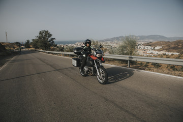 Obraz na płótnie Canvas Man riding a touring motorbike during a trip across the mountains.