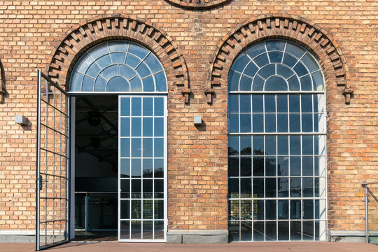 Backsteinfassade eines alten Fabriksgeb&auml;ude mit gro&szlig;fl&auml;chigen Fenstern und sch&ouml;nen Verzierungen