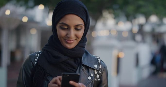 portrait beautiful young muslim woman using smartphone texting browsing messages looking pensive independent female in city