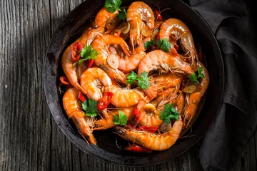 Foto auf gebürstetem Alu-Dibond Meeresfrüchte Top view of shrimps on pan with parsley and garlic