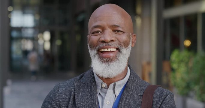 portrait happy mature african american businessman laughing in city enjoying professional urban lifestyle cheerful black man commuter slow motion