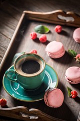 Black coffee and delicious pink macaroons served with hot coffee