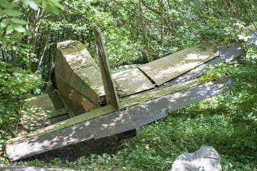 Old airplane crashed in deep green woods. Lost airplane emergency landed in forest, jungle