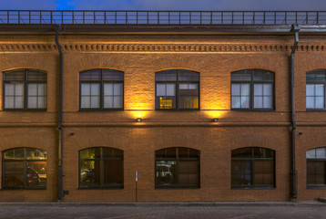 Evening in the old quarter. Office building in loft style. Brick building with large Windows.