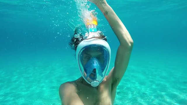 Young man diving with mask on paradisiac beach