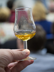 Hand holding a snifter glass filled with whisky