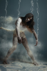 Dancing in flour concept. Muscle fitness guy man male dancer in dust / fog. Guy wearing white...