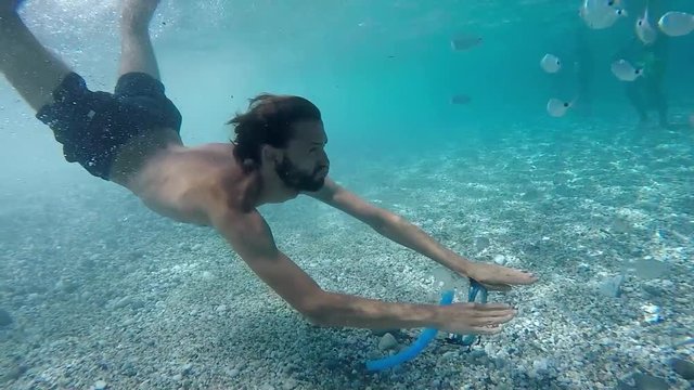 Young man snorkeling on paradisiac beach