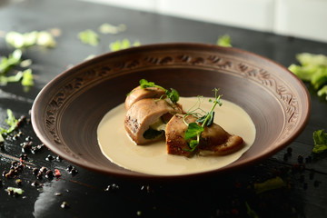 baked chicken fillet with cheese and sauce on a clay plate