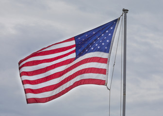 Bright American flag with clouds behind