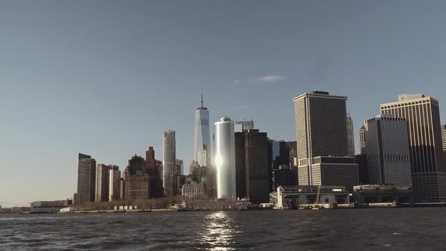 Wide shot of financial skyscrapers in downtown New York in Lower Manhattan filmed from the east river in late afternoon