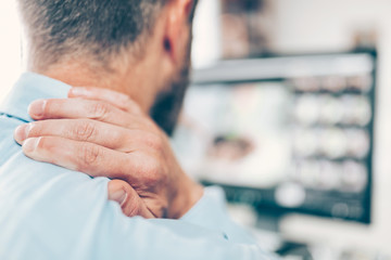 Office worker with neck pain from sitting at desk all day