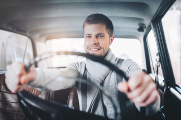 Handsome man sitting inside his vintage car