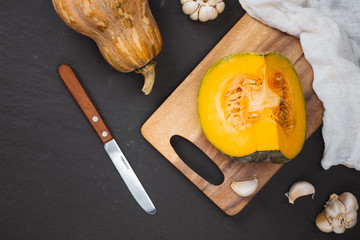 Cut Pieces of Pumpkin with seeds in Wooden Plate on the Wooden Board.Harvest,Fresh Vegetable, Ingredient.White Food Background.Top View