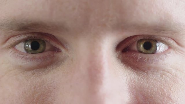 close up of man green eyes opening caucasian male awake looking happy at camera iris focus