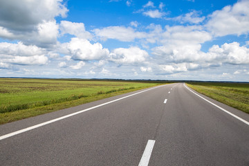 Beautiful and sunny road landscape with sky clouds and yellow fields