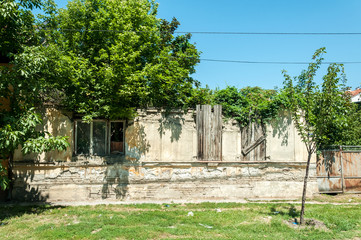 Obraz premium Old ruined house with collapsed roof and broken windows covered with wooden board