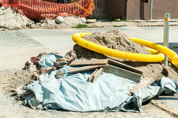 Street reconstruction site with big pile of sand and cement on the asphalt road for installing new...