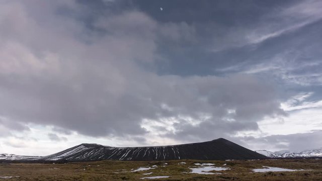 Timelapse sequence of the volcano crater Hverfjall in Iceland with the moon and clouds moving above.