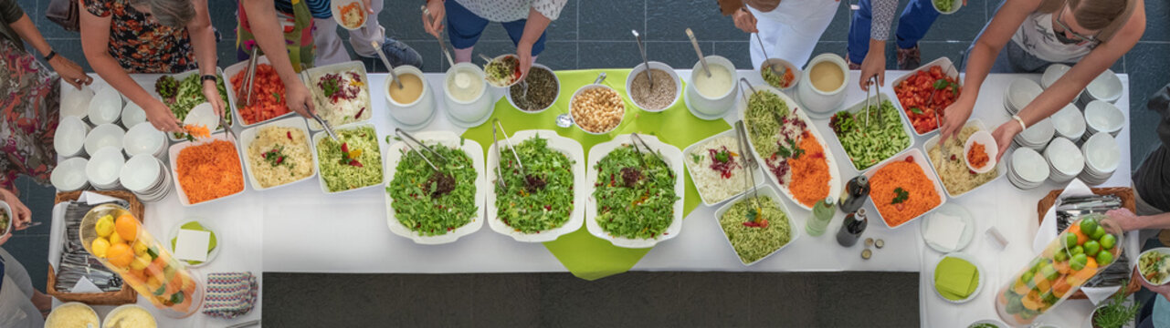Vegetarisches Salat Buffet mit frischen Salaten und Gemüse für ein Catering mit Menschen die sich bedienen
