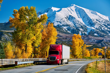 Red truck on highway in Colorado at autumn - 215370948