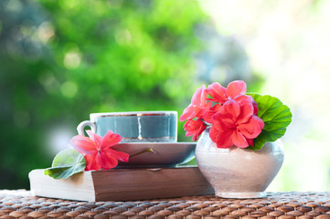 Beautiful summer composition of a cup of tea , flowers and book  on a natural green background, a concept of good morning, summer mood, happiness