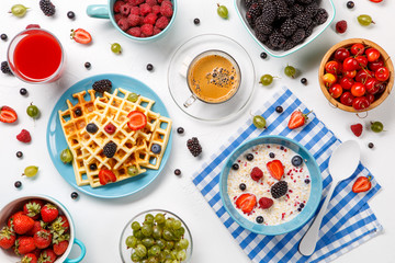 Naklejka premium Photo of Viennese waffles, oatmeal, coffee, raspberries, strawberries, gooseberries