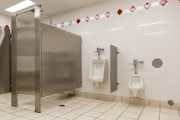 closeup of the open urinals in the male public toilet. Children's and adult urinal. Cab for...