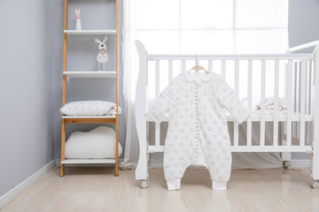 Simple, white baby bedroom with cot and rug