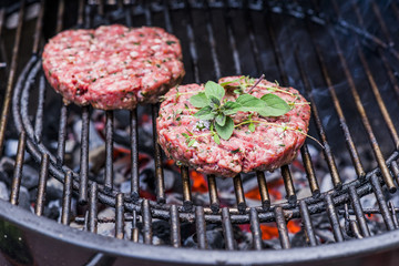 Burgerpattie mit Kräutern auf dem Grill