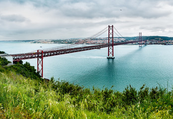 Ponte 25 de Abril Bridge in Lisbon, Portugal. Connects the cities of Lisbon and Almada crossing the Tagus River. View from Almada