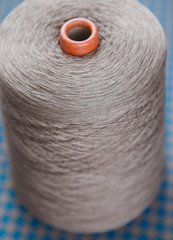Grey colour skein on the blue and grey textile background