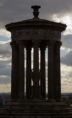 Silhouette of Calton hill monument with a cloudy evening  sky in the background