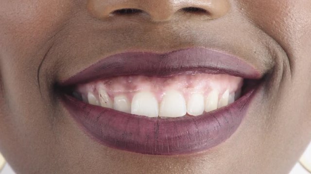 close up african american woman lips smiling happy healthy teeth glossy lipstick makeup cosmetics feminine beauty