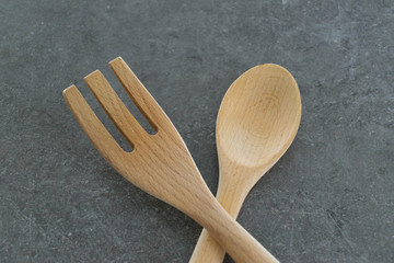 Wooden large spoon and fork on grey background - cooking eating concept