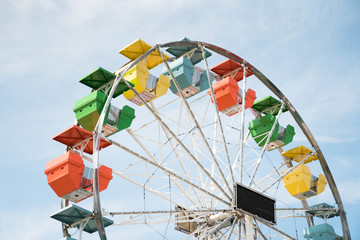 Colourful ferris wheel against partly cloudy sky - 215387964