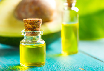 avocado oil cosmetics medicine health nature glass vial wooden background
