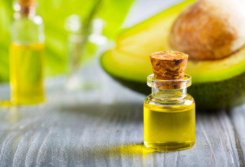 avocado oil cosmetics medicine health nature glass vial wooden background

