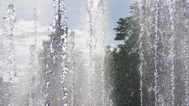 City landscape. Close-up shot of water drops of fountain in the summer park. 4K