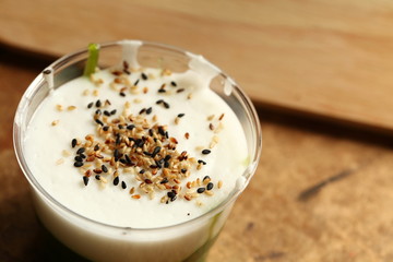 Green coconut sweet pudding in plastic cup scene.