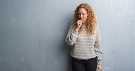 Fototapeta premium Young redhead woman over grey grunge wall feeling unwell and coughing as symptom for cold or bronchitis. Healthcare concept.